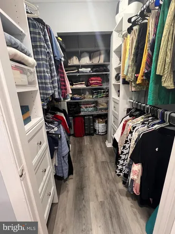 a view of walk in closet with clothes and shoes