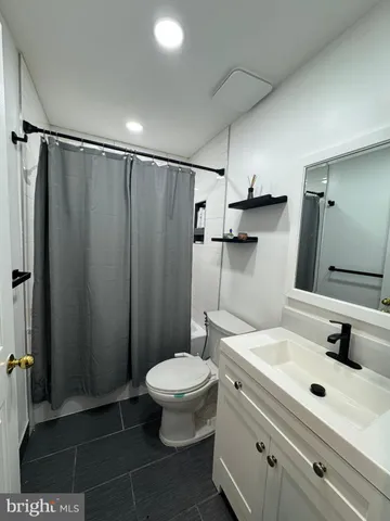 a bathroom with a sink a toilet a mirror and shower