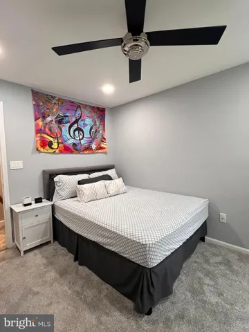 a bedroom with a bed and painting on the wall