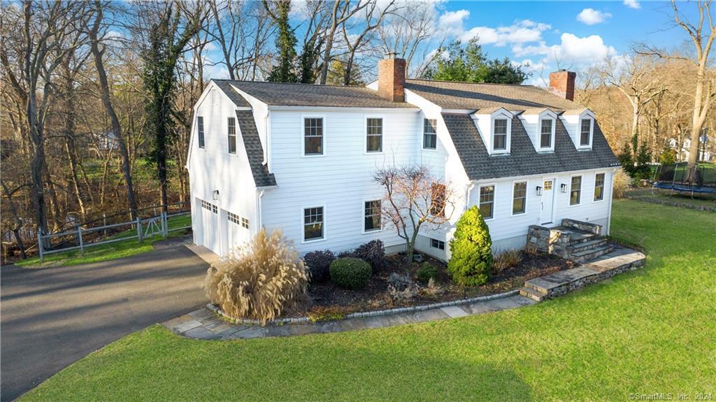a view of a house with a yard and table and chairs next to a yard