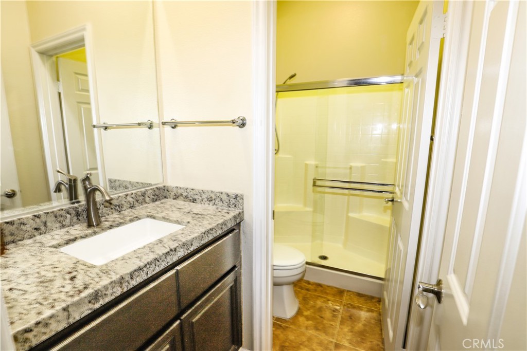 1653 Honors Circle Corona, CA 92883 - Photo 16 of 35 a bathroom with a granite countertop sink and a mirror