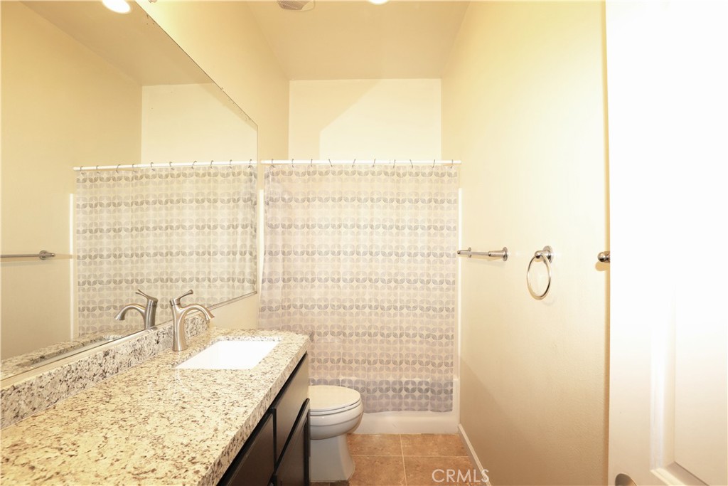 1653 Honors Circle Corona, CA 92883 - Photo 21 of 35 a bathroom with a granite countertop sink toilet and shower