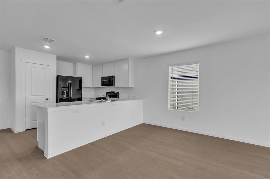 11325 Rodeo Drive Providence Village, TX 76227 - Photo 11 of 40 a kitchen with stainless steel appliances a refrigerator sink and white cabinets