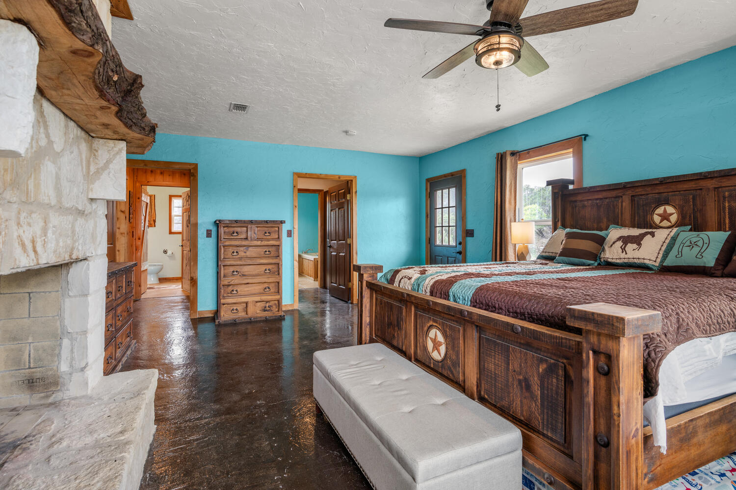 3487 Rust Spring Branch, TX 78070 - Photo 13 of 40 The owner's retreat offers a comfortable, rustic vibe with a cozy pass-through fireplace and an exterior door to the deck.