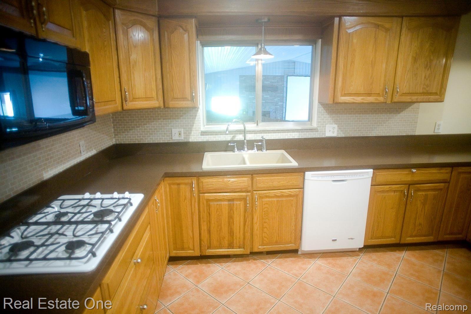 42560 Willis Road Belleville, MI 48111 - Photo 11 of 70 STOVE TOP AND MICROWAVE - VIEW TO POOL ROOM.