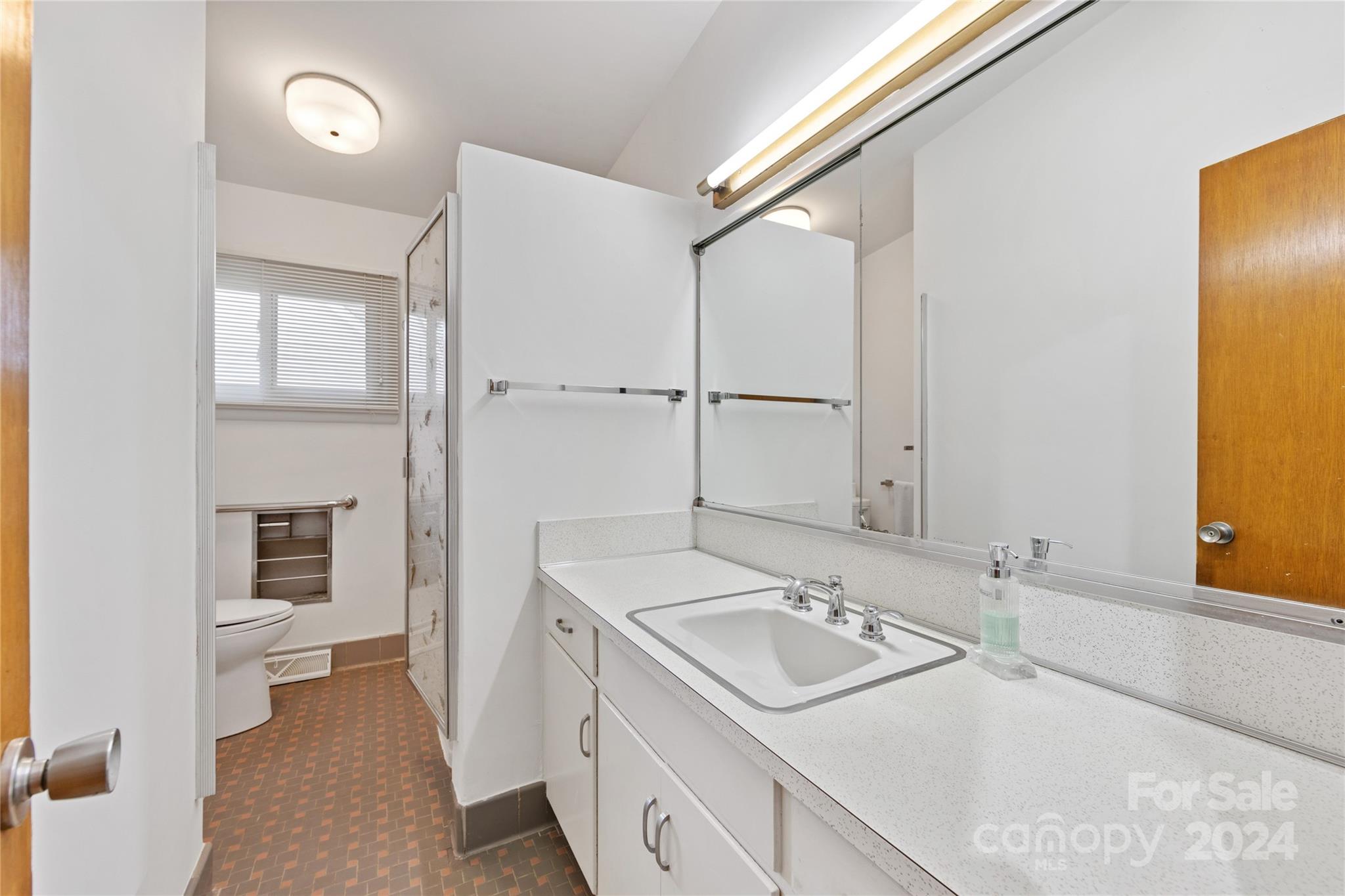 3239 Foxcroft Road Charlotte, NC 28211 - Photo 15 of 42 a bathroom with a sink and mirror with toilet