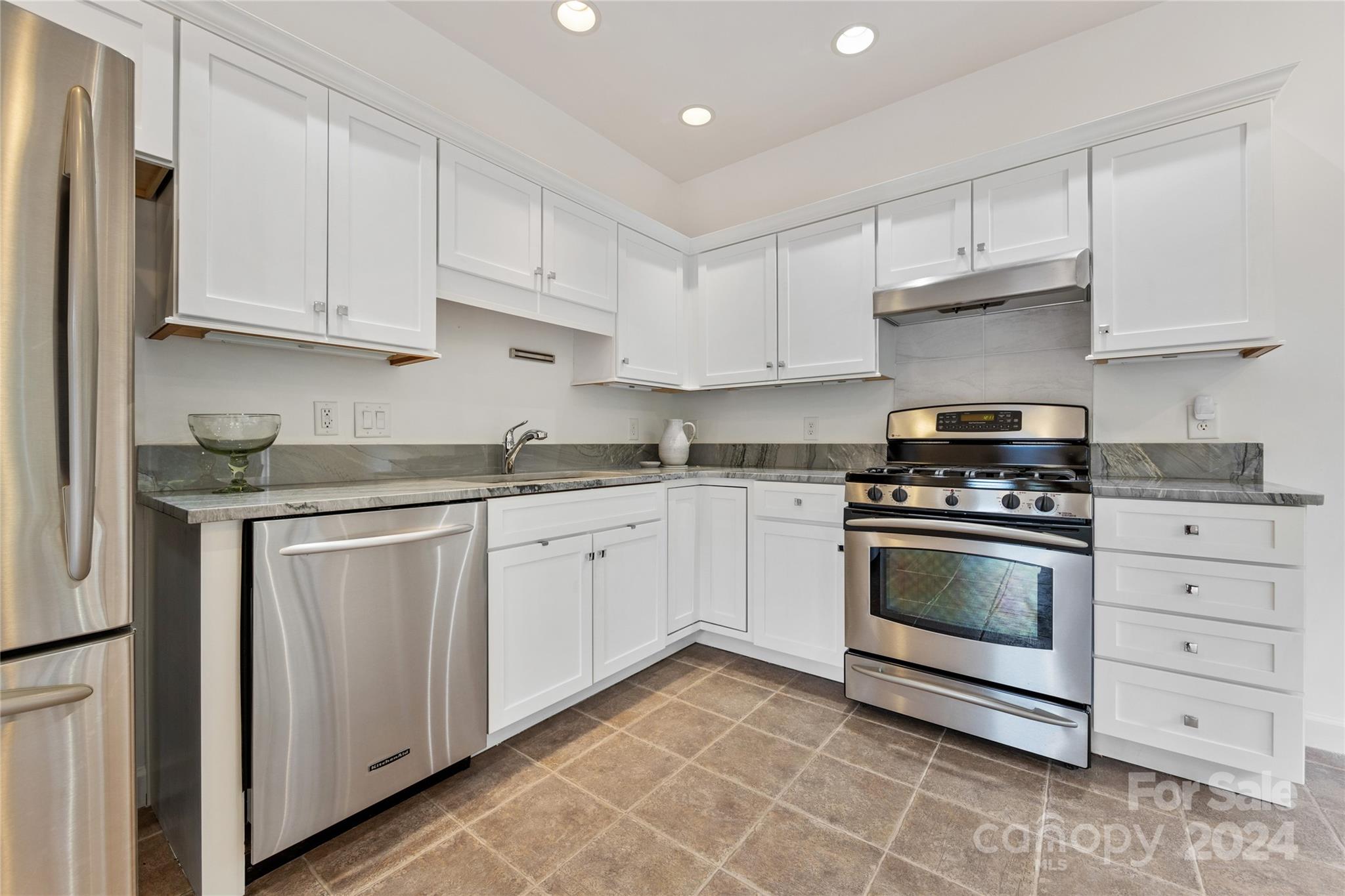 3239 Foxcroft Road Charlotte, NC 28211 - Photo 30 of 42 a kitchen with granite countertop white cabinets and stainless steel appliances