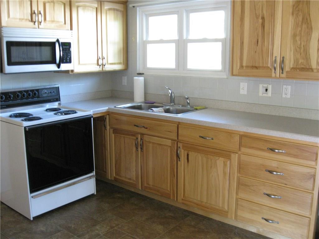 3108 Mercer Road New Castle, PA 16105 - Photo 6 of 17 Kitchen with nearby sunroom. Electric stove and microwave included with no warranties.