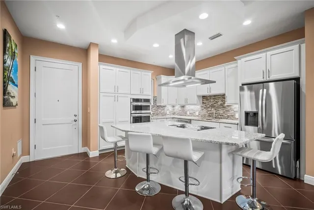a kitchen with stainless steel appliances a refrigerator a stove a sink and a island