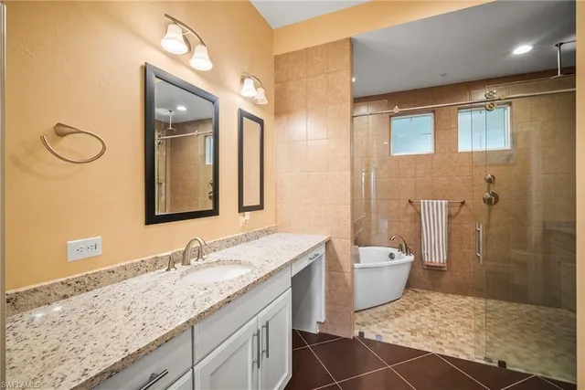 a spacious bathroom with a granite countertop sink a toilet a mirror and shower