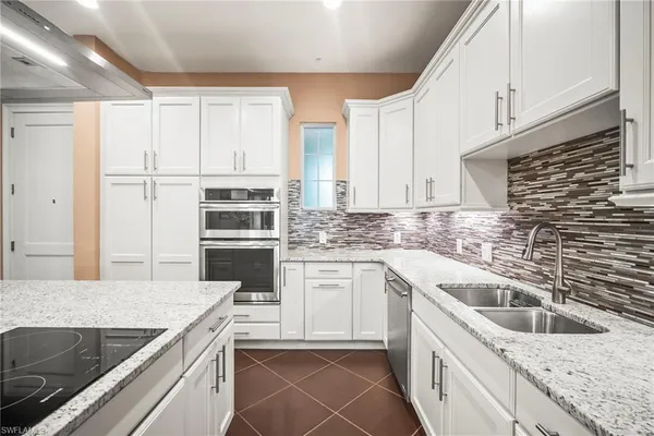 a kitchen with a sink stove top oven and cabinets