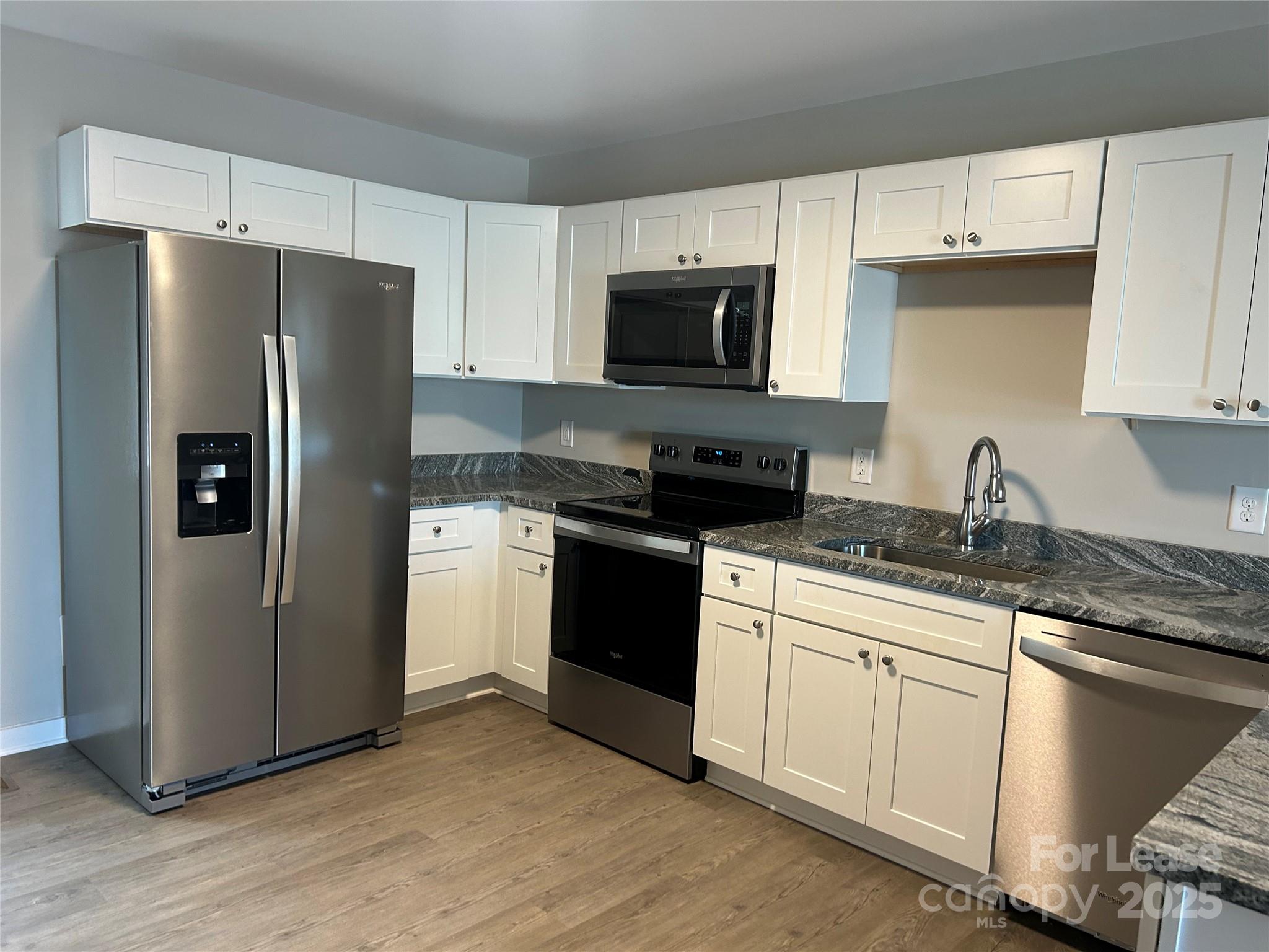 3297 Paul Elmore Road Lincolnton, NC 28092 - Photo 2 of 14 a kitchen with stainless steel appliances granite countertop a refrigerator stove a sink and dishwasher with wooden floor