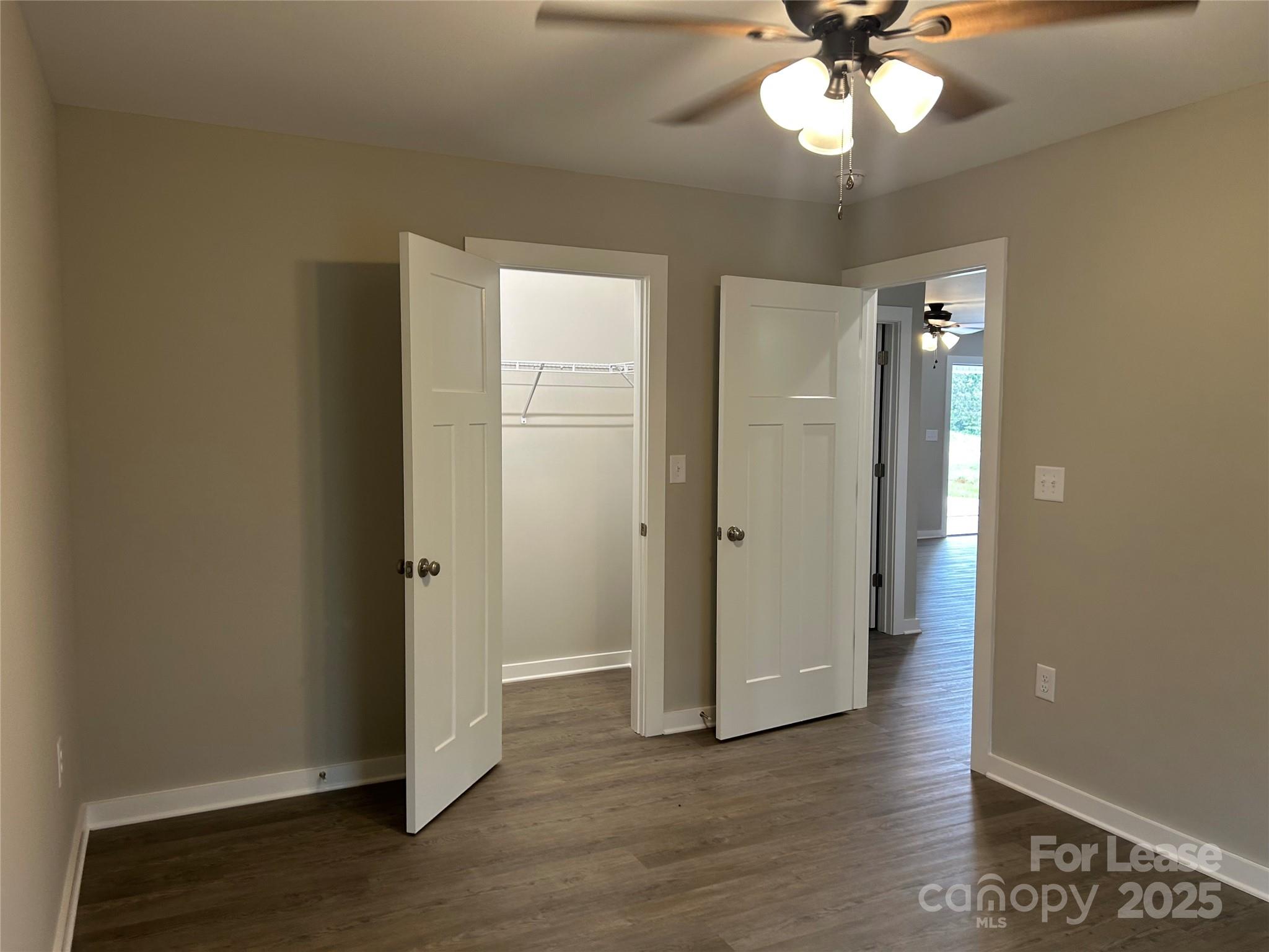 3297 Paul Elmore Road Lincolnton, NC 28092 - Photo 9 of 14 an empty room with wooden floor chandelier fan and closet area