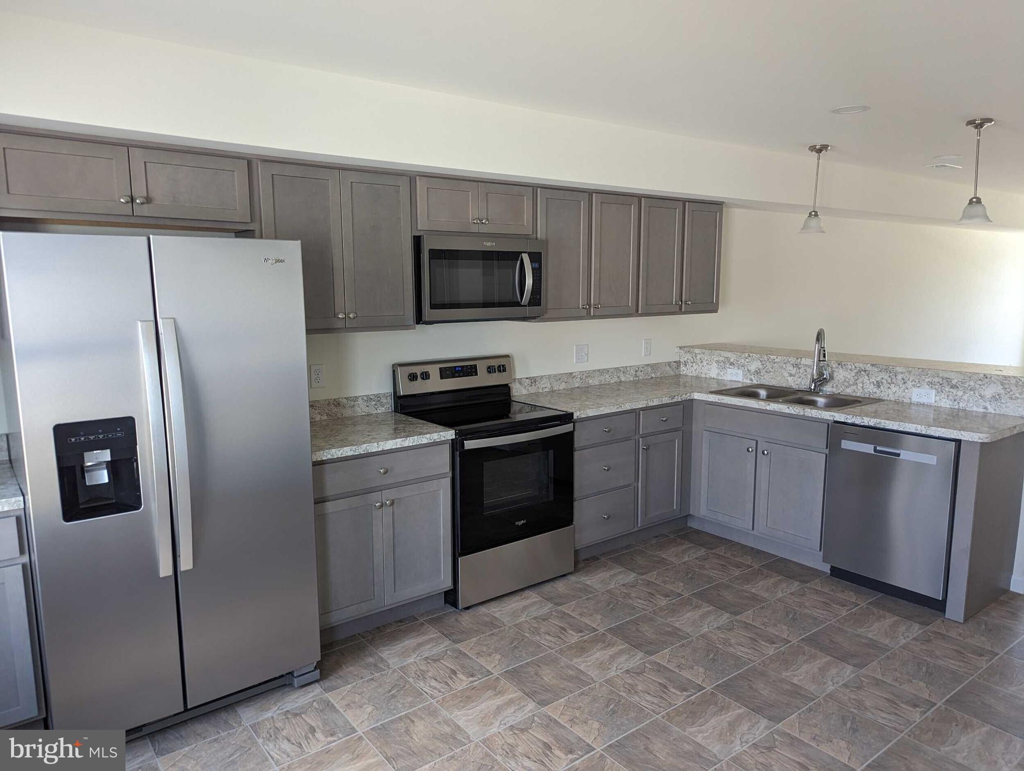 227 Rojan Road Dover, DE 19901 - Photo 5 of 20 a kitchen with stainless steel appliances granite countertop a refrigerator a sink a stove a microwave and wooden cabinets