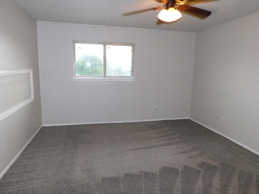 1007 Windy Trail, Unit A Austin, TX 78758 - Photo 8 of 10 Spare room with a ceiling fan, dark carpet, and baseboards