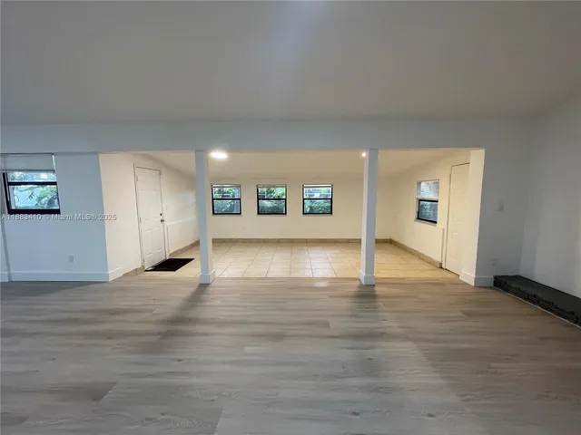 a view of empty room with wooden floor