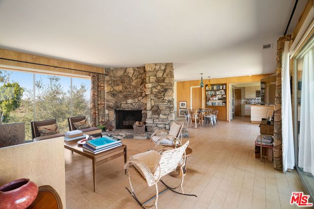 a living room with furniture a fireplace and a floor to ceiling window