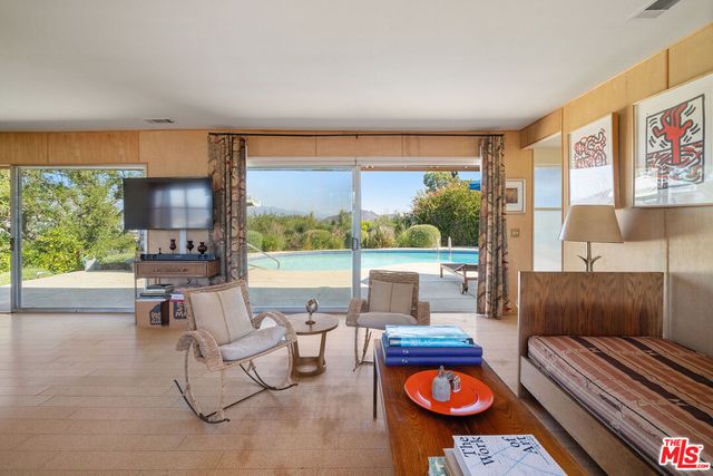 a living room with furniture and a floor to ceiling window