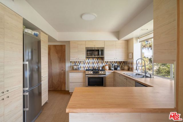 a kitchen with stainless steel appliances granite countertop a refrigerator and a sink