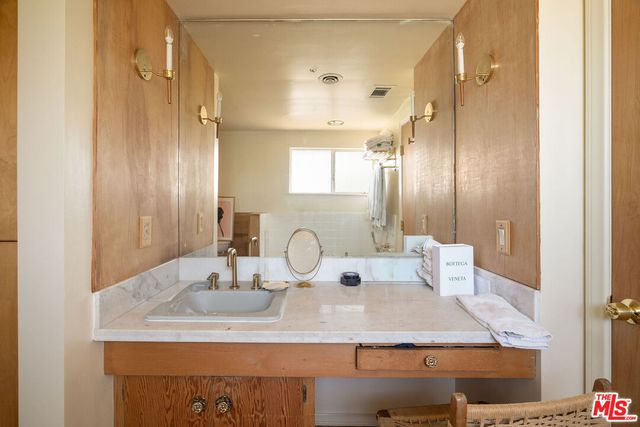 a bathroom with a granite countertop sink a mirror and a shower