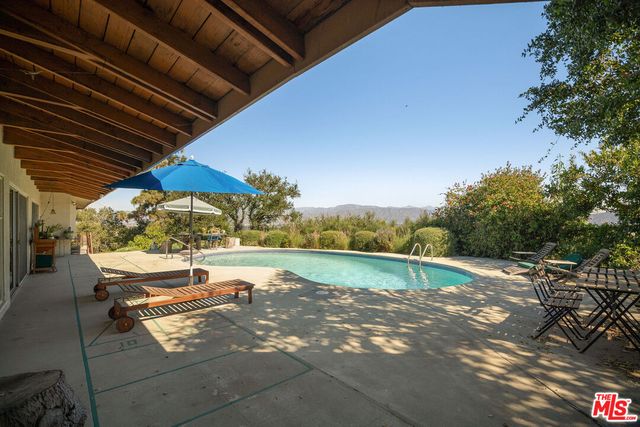 a view of a backyard with table and chairs under an umbrella