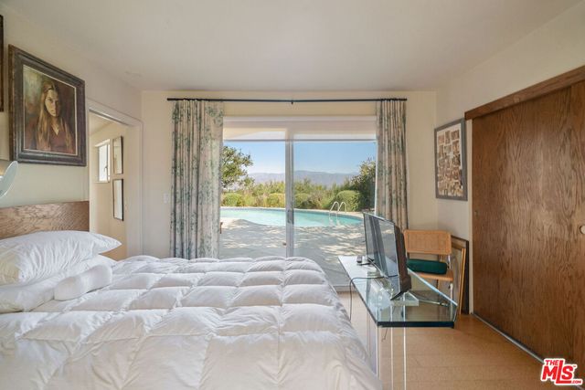 a bedroom with a bed and a large window