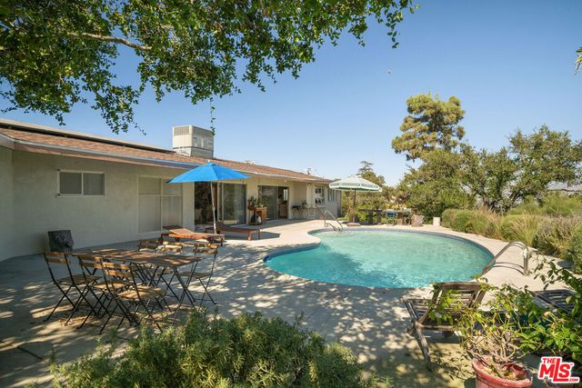 a view of a backyard with table and chairs under an umbrella