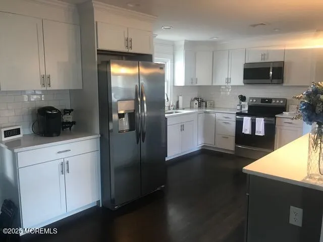 a kitchen with a refrigerator and a stove top oven