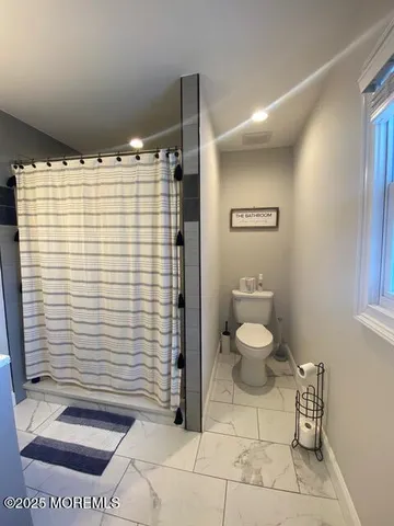 a bathroom with a toilet and a shower