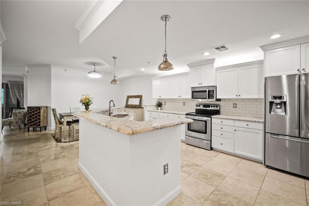 8701 Piazza Del Lago Circle, Unit 101 Estero, FL 33928 - Photo 19 of 50 a kitchen with appliances cabinets and a counter top space