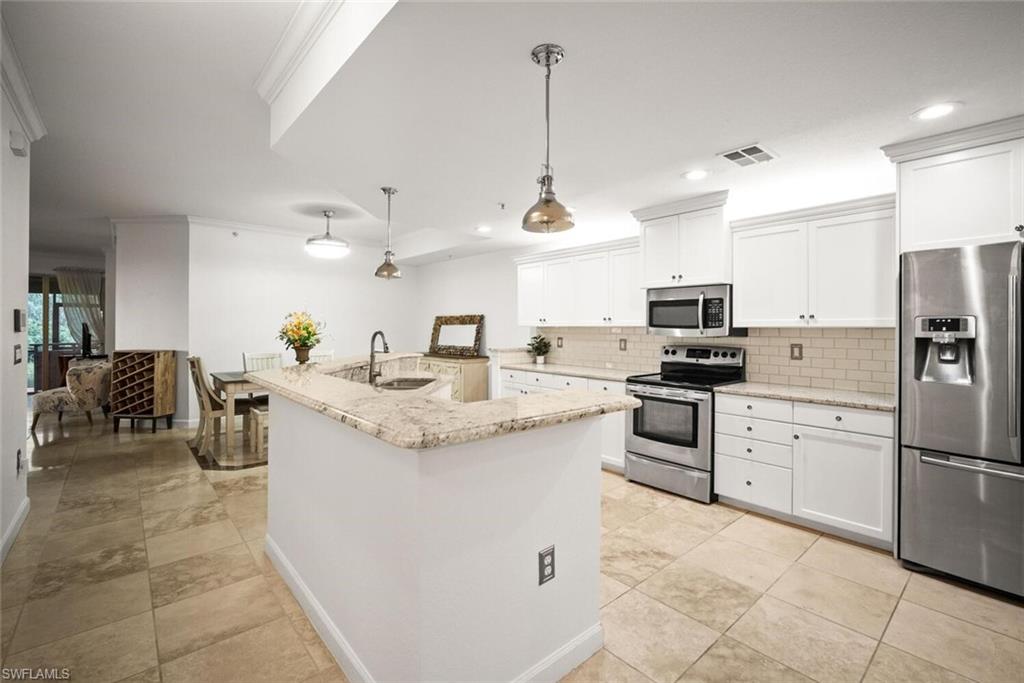 8701 Piazza Del Lago Circle, Unit 101 Estero, FL 33928 - Photo 20 of 50 a kitchen with appliances cabinets and a counter top space