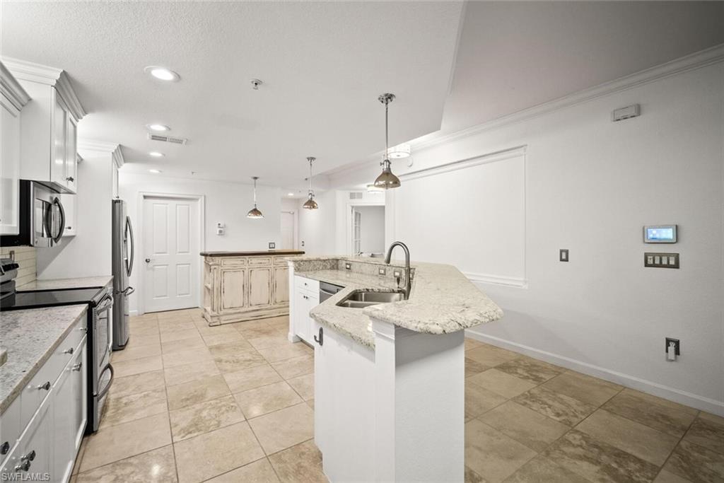8701 Piazza Del Lago Circle, Unit 101 Estero, FL 33928 - Photo 21 of 50 a kitchen with stainless steel appliances granite countertop a sink stove and cabinets