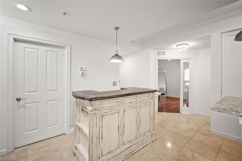 8701 Piazza Del Lago Circle, Unit 101 Estero, FL 33928 - Photo 25 of 50 a kitchen with stainless steel appliances granite countertop a sink and a refrigerator