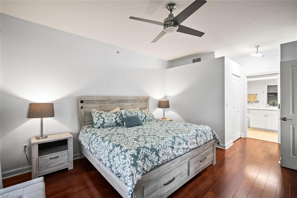 8701 Piazza Del Lago Circle, Unit 101 Estero, FL 33928 - Photo 28 of 50 a bedroom with a bed and wooden floor
