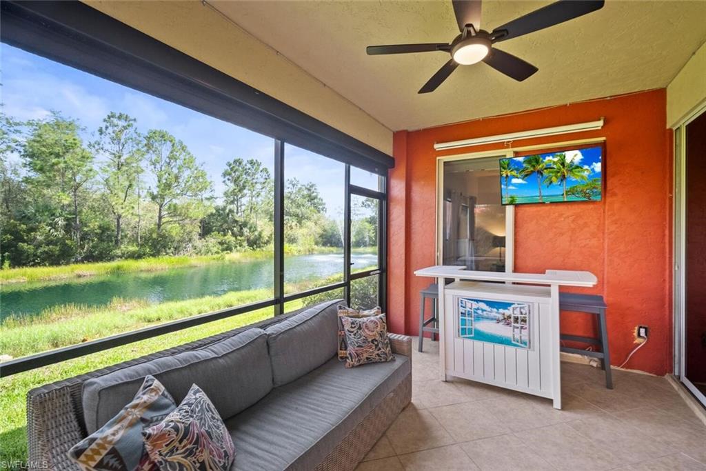 8701 Piazza Del Lago Circle, Unit 101 Estero, FL 33928 - Photo 4 of 50 a living room with furniture and a floor to ceiling window