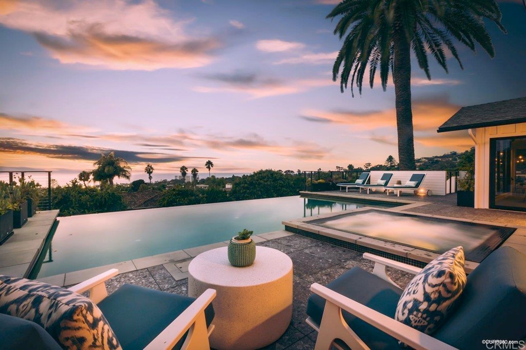 a view of swimming pool with seating area and lake view