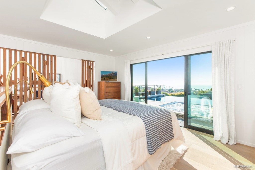 1237 Muirlands Vista Way La Jolla, CA 92037 - Photo 12 of 25 a bedroom with a large bed and a large window