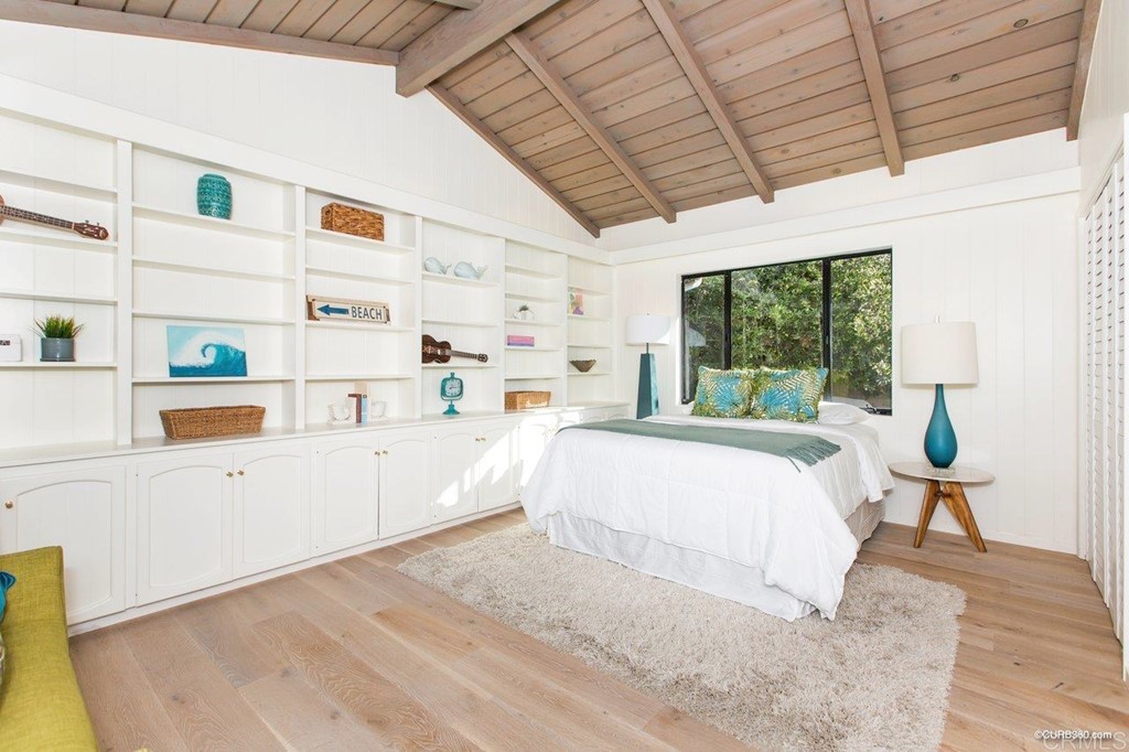1237 Muirlands Vista Way La Jolla, CA 92037 - Photo 18 of 25 a bedroom with a bed wooden floor and window