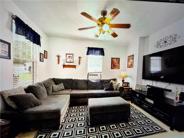 a living room with furniture a air conditioner and a window