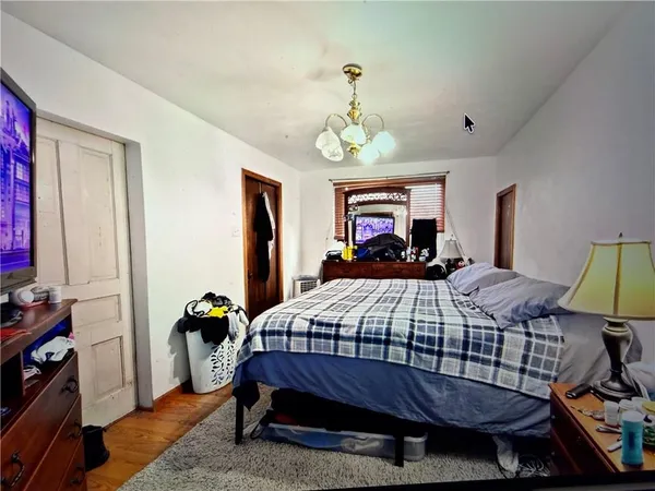 a bedroom with a bed and a chandelier