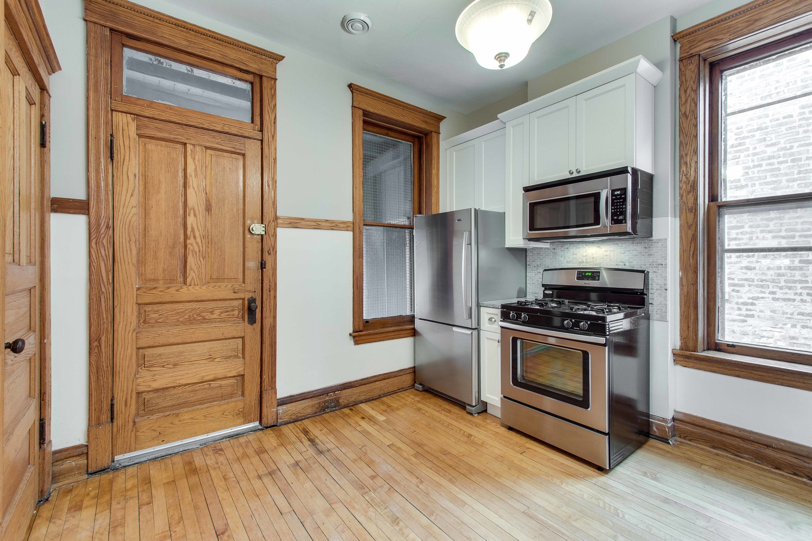 2905 West Logan Boulevard Chicago, IL 60647 - Photo 30 of 36 a kitchen with a refrigerator stove and wooden cabinets
