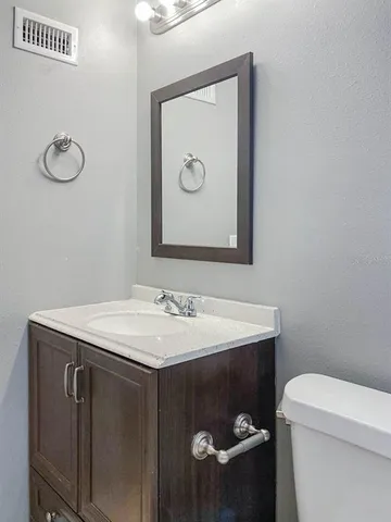 a bathroom with a sink toilet and mirror