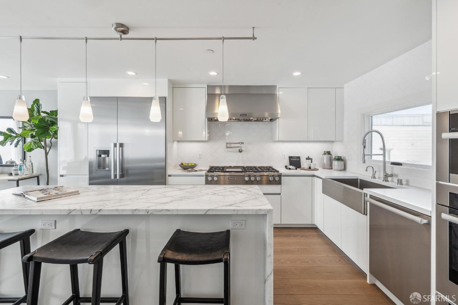 340 25th Avenue San Francisco, CA 94121 - Photo 15 of 73 a kitchen with stainless steel appliances granite countertop a sink a stove a refrigerator and island with wooden floor