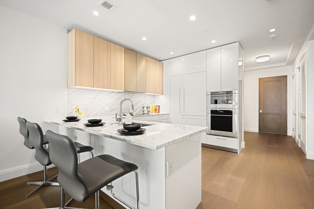 240 Devonshire Street, Unit 5503 Boston, MA 02110 - Photo 7 of 42 a kitchen with a sink cabinets and wooden floor