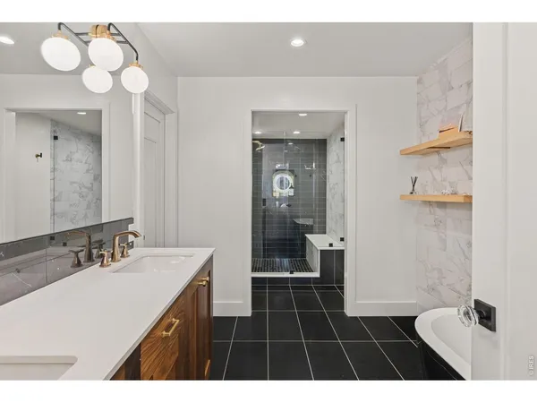 a bathroom with a sink a toilet a mirror and a shower