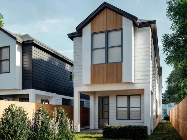 a front view of a house with plants and entryway