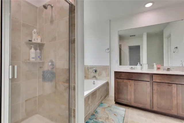 a bathroom with a double vanity sink mirror and shower