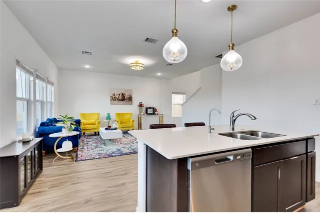 a very nice looking dining room with kitchen island stainless steel appliances and wooden floor