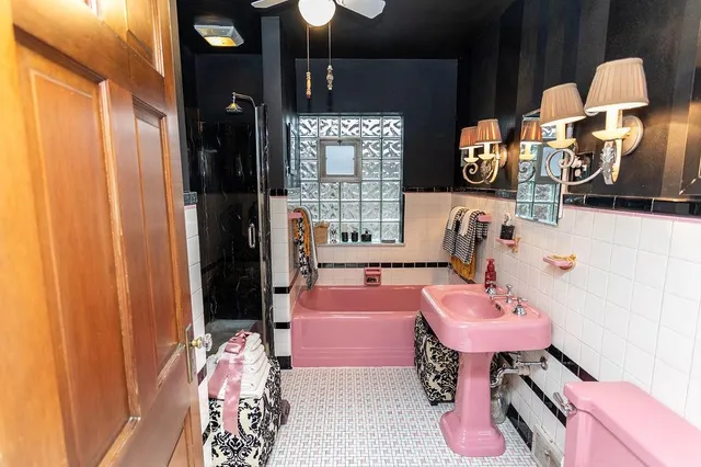 a bathroom with a tub sink and mirror