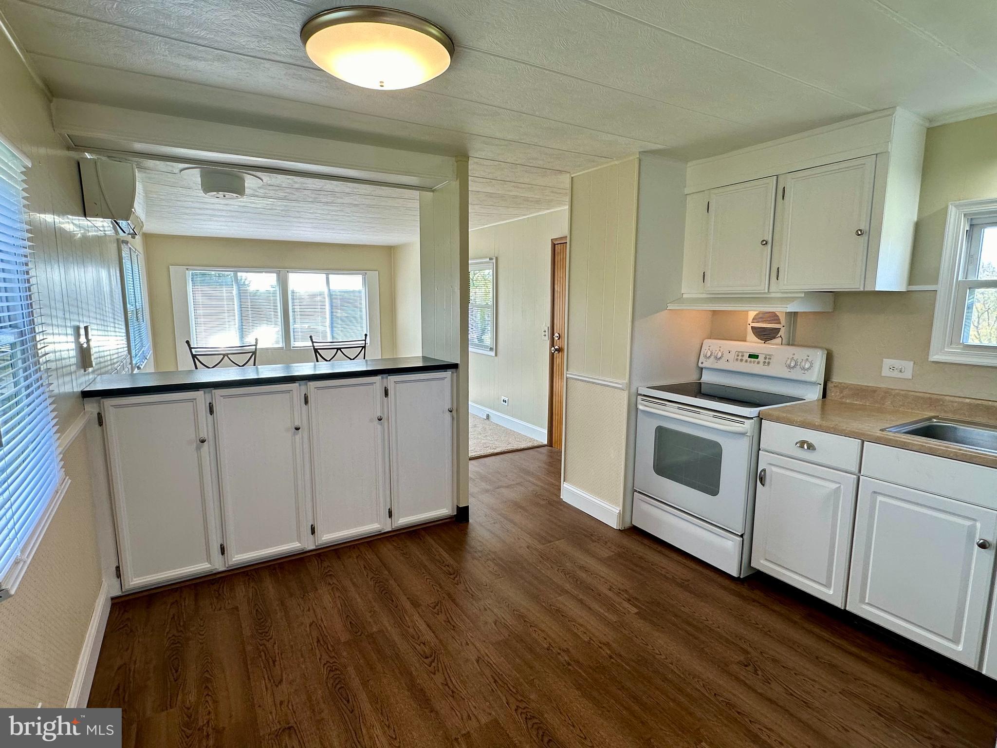 a kitchen with granite countertop white cabinets and white appliances